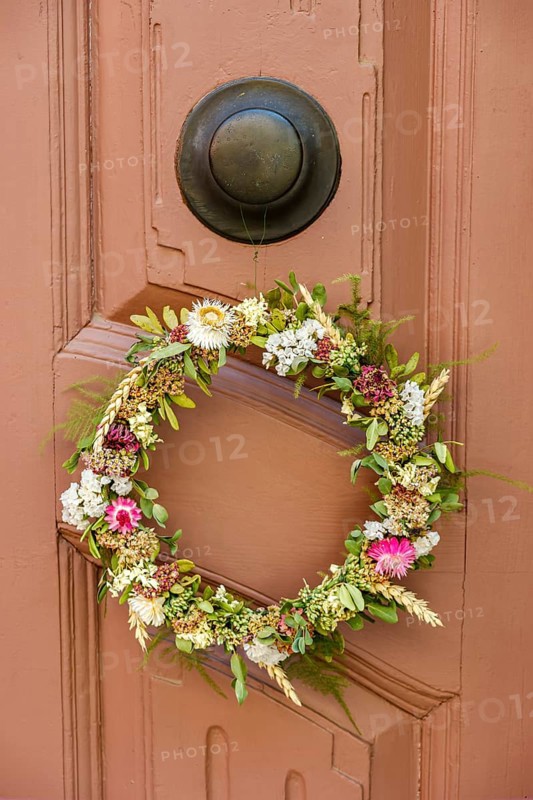 Detail of an antiquated front door with floral wreath in a building on the Krämerbrücke in the historic city centre of Erfurt, Thuringia, Germany, Europe