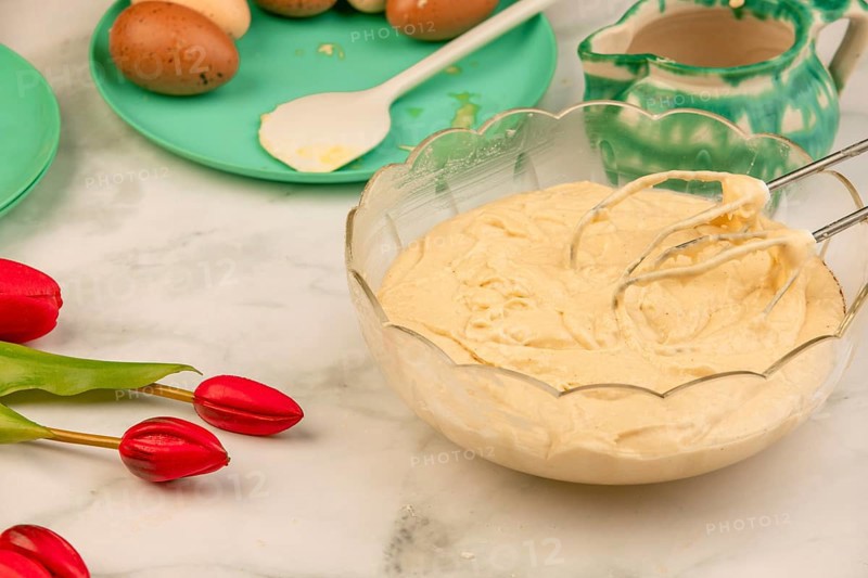 Finished dough in a bowl with ingredients in the background