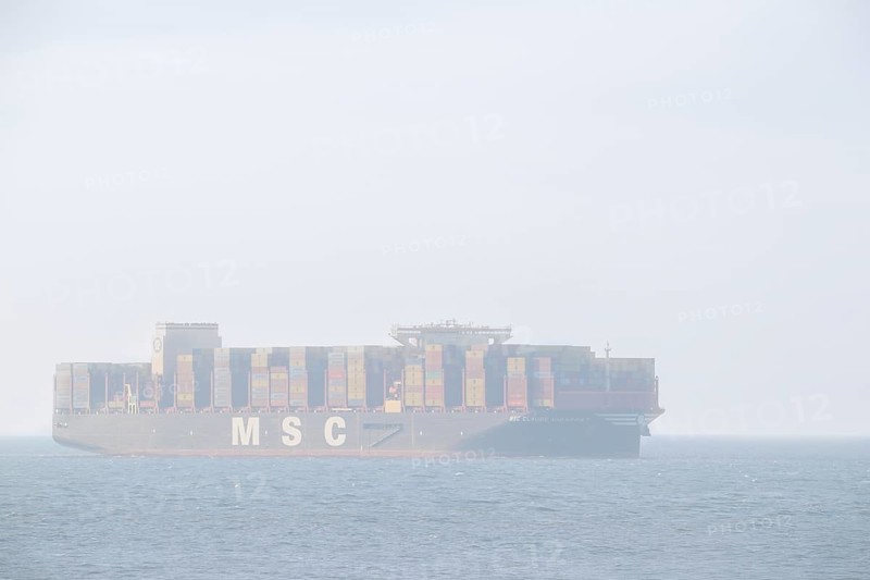 Container ship, containership MSC Claude Girardet from Mediterranean Shipping sailing with containers under the flag of Liberia in thick fog, mist