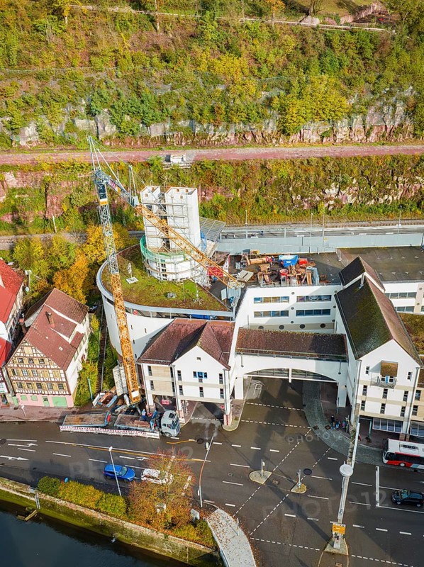Construction site with crane and concrete tower above an overpass in an autumn landscape, extension of the ZOB Calw tower onto the new track of the Hermann Hesse railway, Calw, Black Forest, Germany, Europe