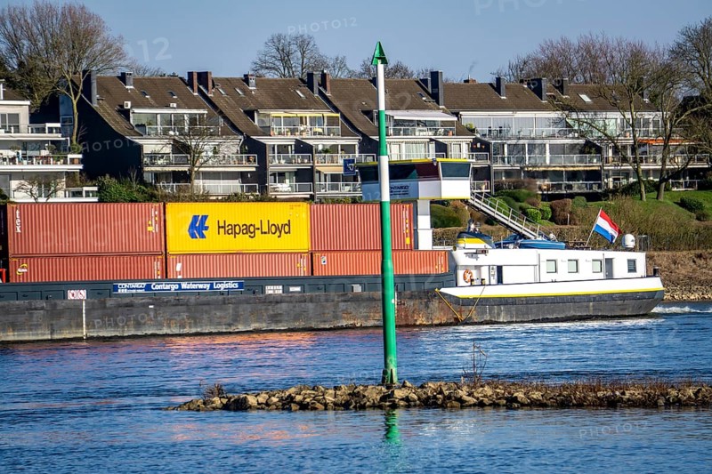 Container cargo ship on the Rhine near Düsseldorf-Bockum, villas on the banks of the Rhine, the neighbourhood in district 5 is one of the most expensive residential areas in Düsseldorf, North Rhine-Westphalia, Germany, Europe