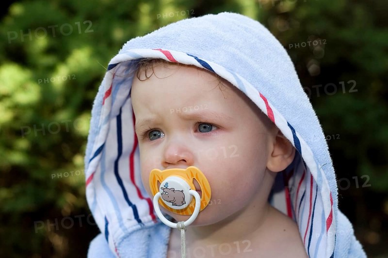 One-year-old boy with bathrobe, baby with dummy, teat