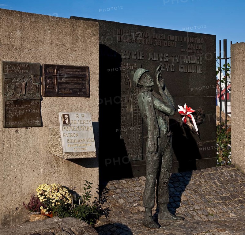 Monument to the Fallen Shipyard Workers, personal memorial plaques on the left, bronze sculpture of a shipyard worker on the right
