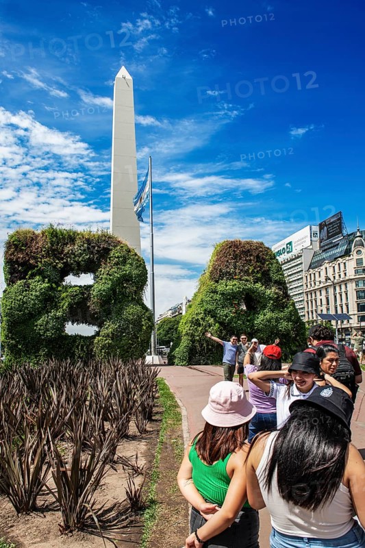 Tourists photograph themselves in front of the plant gates in the shape of the letters of Buenos Aires, in front of the obelisk, Avenida 9 de Julio, Plaza de la Republica, Buenos Aires