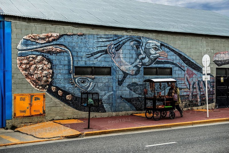 Mural with mythological whale and street vendor in the harbour of Ushuaia, Argentina, South America