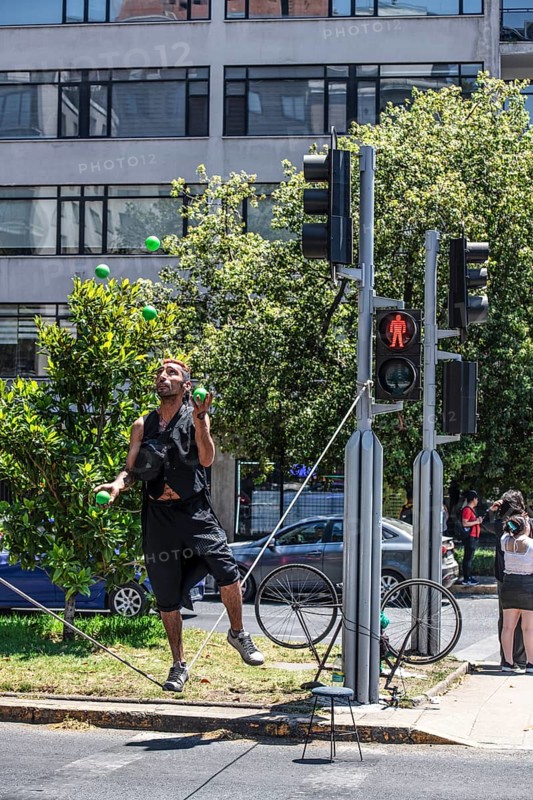 Street artist dances on a rope and juggles between two traffic lights, Santiago de Chile, Chile, South America