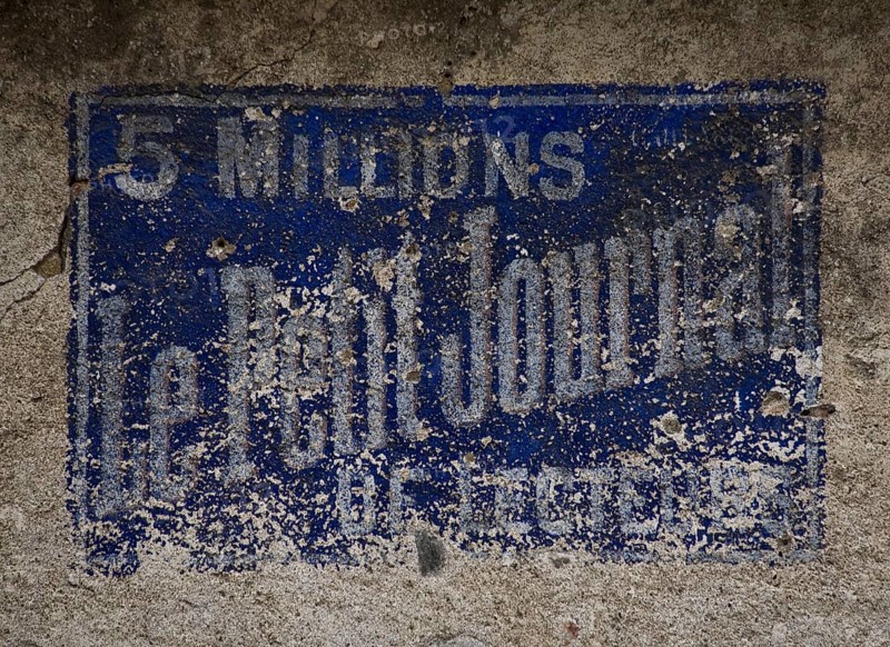 Weathered, historic wall advertisement LE PETIT JOURNAL (5 million readers) in Hérisson (Allier)