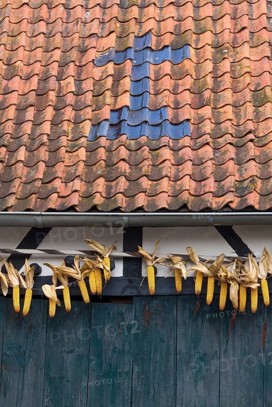 Barn with cross made of roof tiles and corn cobs