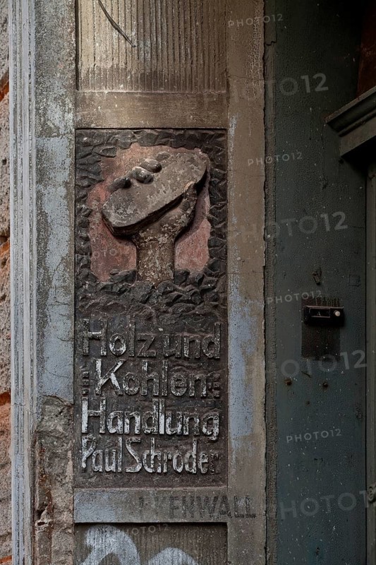 Advertising relief of a coal merchant, weathered left side of the portal Holz und Kohlenhandlung Paul Schröder