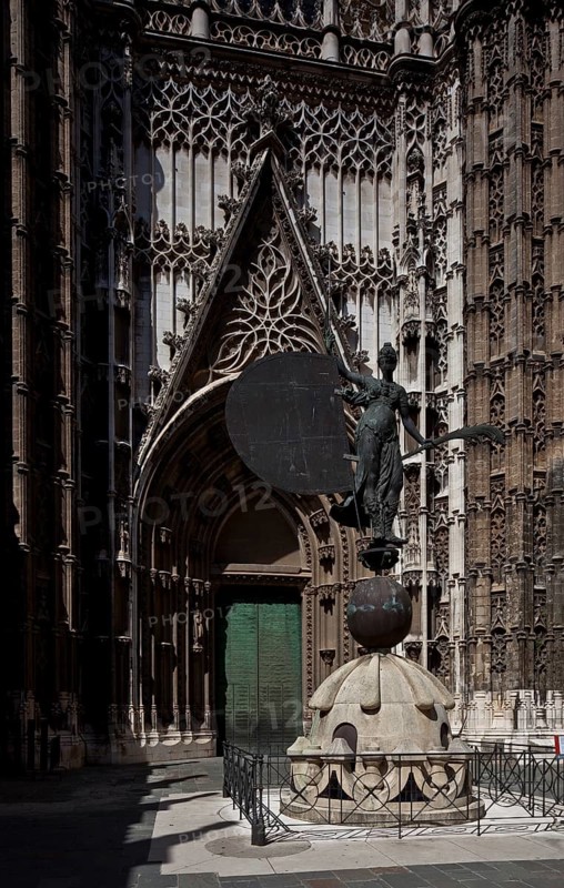 Seville, Cathedral. South portal in front of it Original of the bronze sculpture crowning the bell tower GIRALDA as a weather vane Sevilla, St., Sankt, Saint