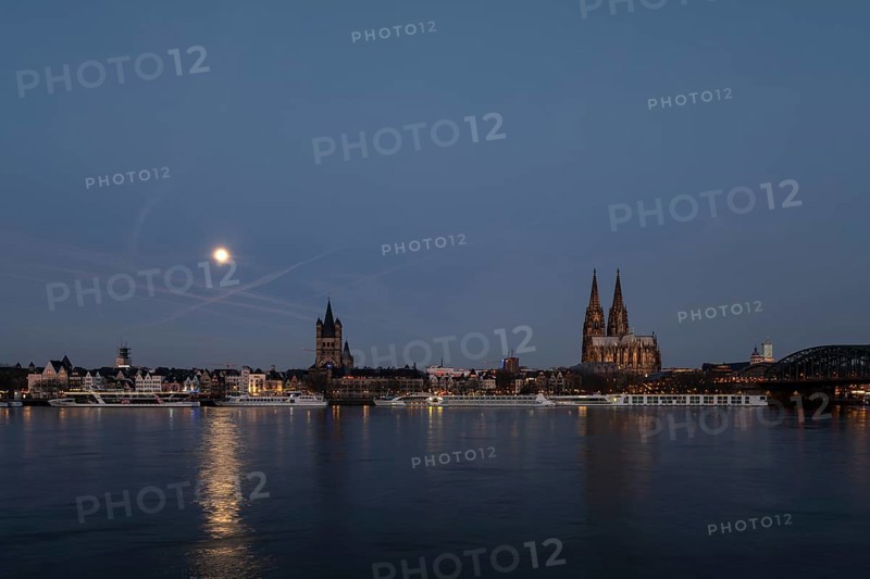 Cologne, view from the right bank of the Rhine to the cathedral, St Martin's Cathedral and the town hall shortly in front of sunrise at full moon