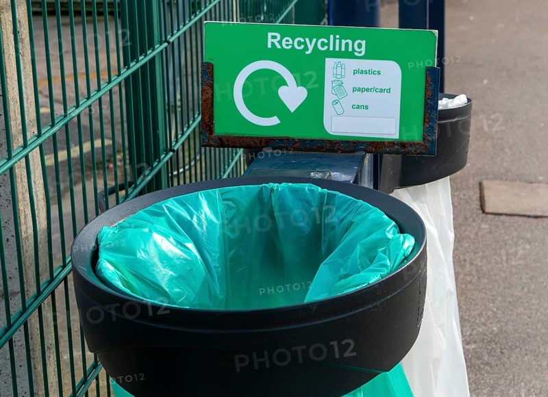Green plastic bag in bin for recycling, UK