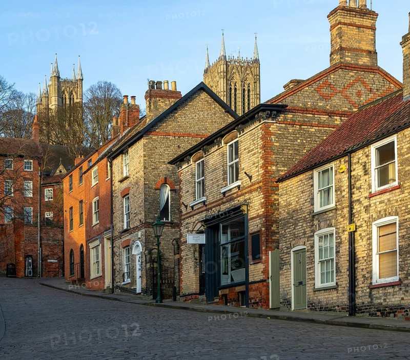 Cathedral towers rising above buildings, Steep Hill in evening light, Lincoln, Lincolnshire, England, UK