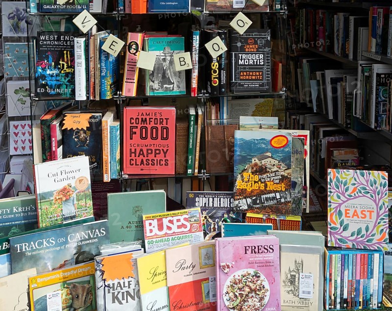 Shop window display of secondhand books in Dorothy House charity shop, Chippenham, Wiltshire, England, UK