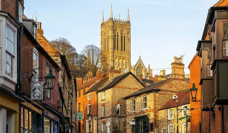 Cathedral tower rising above buildings, Steep Hill in evening light, Lincoln, Lincolnshire, England, UK