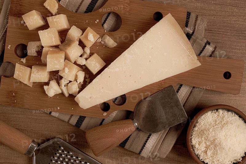Freshly sliced and grated cheese, parmesan cheese, Gran gusto. Grana padano. on a wooden chopping board, rustic style, no people
