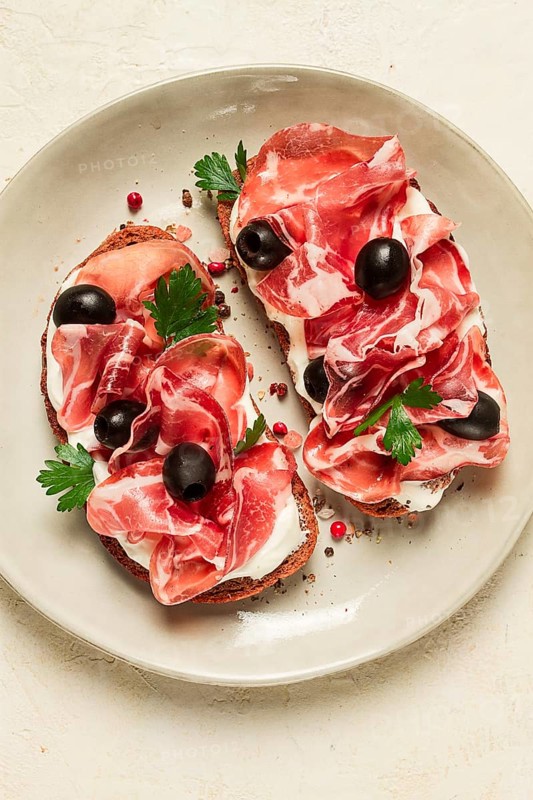 Sandwich with cream cheese, prosciutto with olives, breakfast