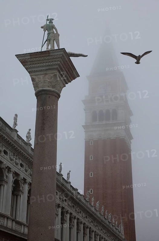 Italy Venice Piazzetta -30 monolithic column with figure of St Theodore Composition of the 14th century from spolia of the 2nd century BC - 2nd century AD behind in the mist Campanile of San Marco