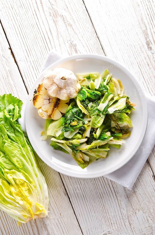 Baked Romaine lettuce with garlic and pine cores