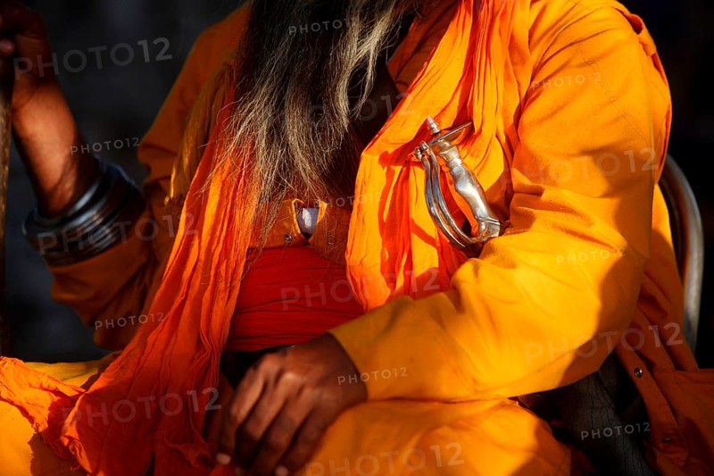 Nihang or Sikh warrior dressed up in orange robes with sword during celebrations of Hola Mohalla at Anandpur sahib in Rupnagar