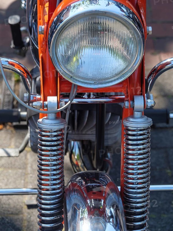 Frontal view of an orange motorbike with shiny chrome headlight, Appelhülsen, münsterland, germany