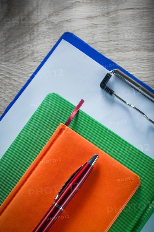 Clipboard notebooks biro pen on wooden board