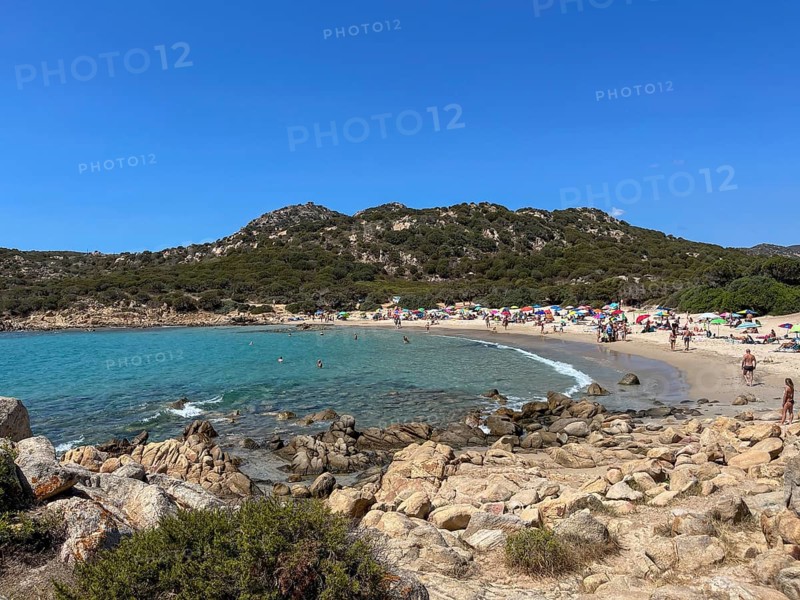 Lively beach with people and blue water, cagliari, sardinia, italy