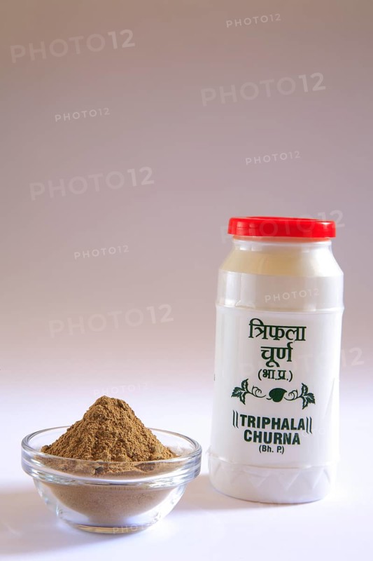 Ayurvedic medicine triphala churna powder for relief from chronic constipation and associated symptoms in plastic bottle