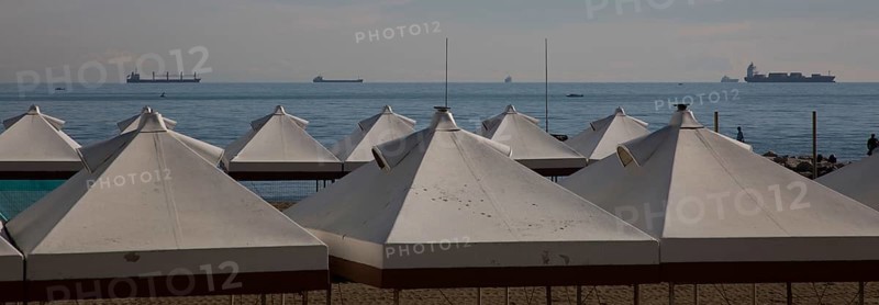 Italy Venice Lido -10 beach tents at the back of the Adriatic Sea with cargo ships in the roadstead
