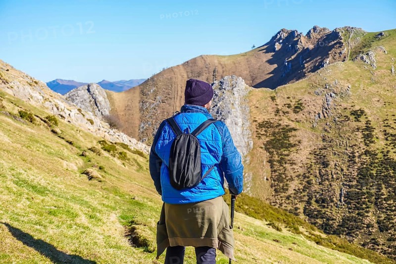 Hiker enjoying the stunning landscape of mount txindoki in gipuzkoa, basque country, on a sunny day