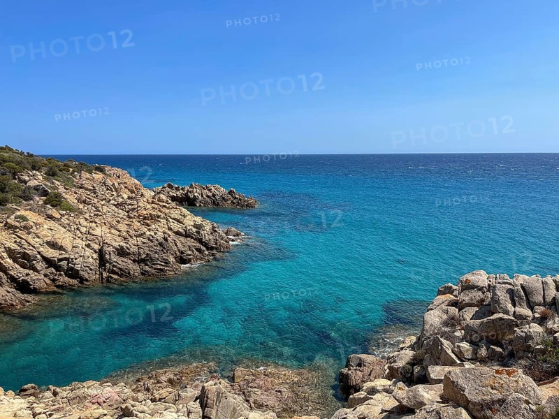 Rocky cliffs tower over the turquoise sea under a clear sky, cagliari, sardinia, italy