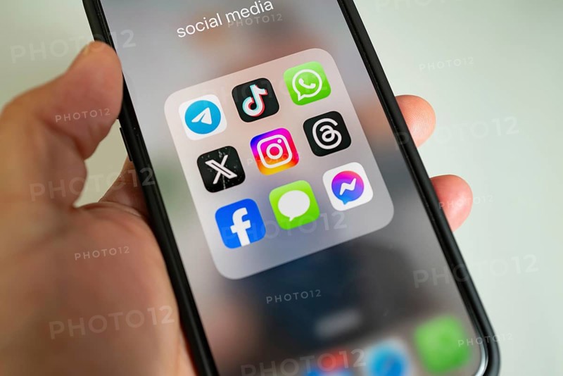 Close-up of a smartphone held in the hand, showing app icons, WhatsApp, Tik Tok, X, Facebook and Messages app, instant messenger service, social networks
