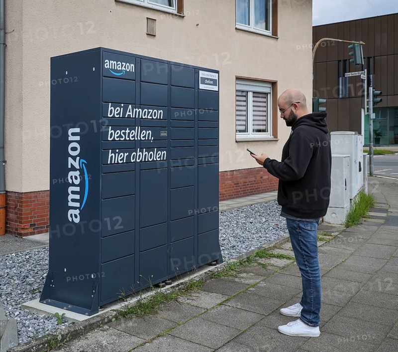 Bottrop, North Rhine-Westphalia, Germany, Amazon, Amazon Locker, Amazon Hub, Packstation, parcel station, pick-up station, customer picks up parcel, a customer opens a flap with an app on his mobile phone and removes his parcel, Europe