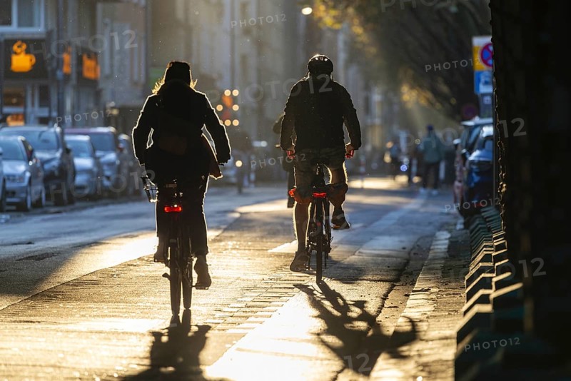 Cyclists in oblique sunlight in November, poor visibility, danger of glare, cycle lane, cyclists have priority over motor traffic, Cologne, North Rhine-Westphalia, Germany, Europe