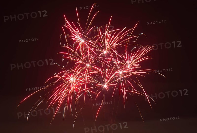 Red fireworks glow in vivid trails of light in the dark, Lower Saxony, Germany, Europe