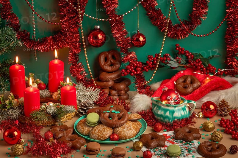 Lavishly decorated table with Christmas decorations, Advent wreath with four lit candles and biscuits