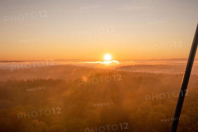 The sun rises over misty forests, bathing the landscape in warm light, Herrenberg, Schönbuchturm, Germany, Europe