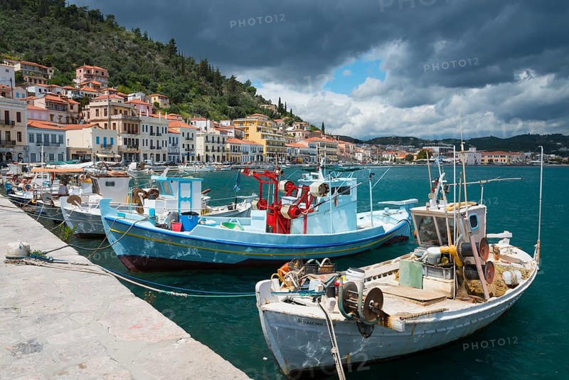 Boats moored at a pier of a coastal town under a slightly cloudy sky with green hills in the background, harbour, Gythio, Mani, Laconia, Peloponnese, Greece, Githio, Gythion, Europe