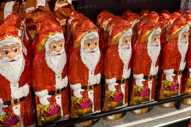 Display in shelf of wholesale of chocolate Father Christmases chocolate Father Christmases Father Christmas Father Christmas chocolate Father Christmases chocolate Father Christmases Father Christmases in colour red of red staniol paper of chocolate arranged like army of Father Christmas, Germany, Europe