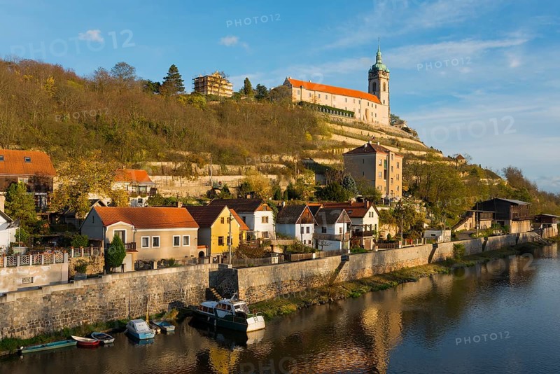 Idyllic town view with church on a hill by the river in the evening sun, surrounded by autumnal nature, Melnik Castle, Church of St. Peter and Paul, Melnik, Melnick, River Elbe, Central Bohemia, Czech Republic, Europe