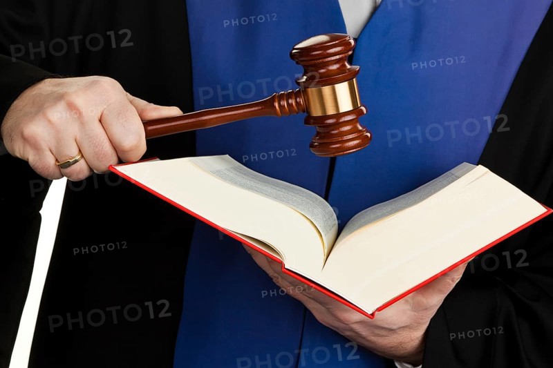 A judge with a law book in court. Gavel in hand, A judge with a law book in court. Gavel in hand. Austria