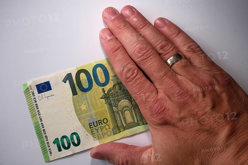 Symbol photo for cash, 100 euro note half covered by a hand, North Rhine-Westphalia, Germany, Europe
