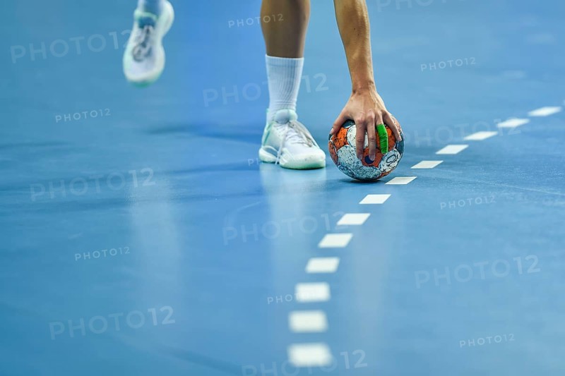 Handball - women's hand taking a ball laying on the 9 meters dotted line.