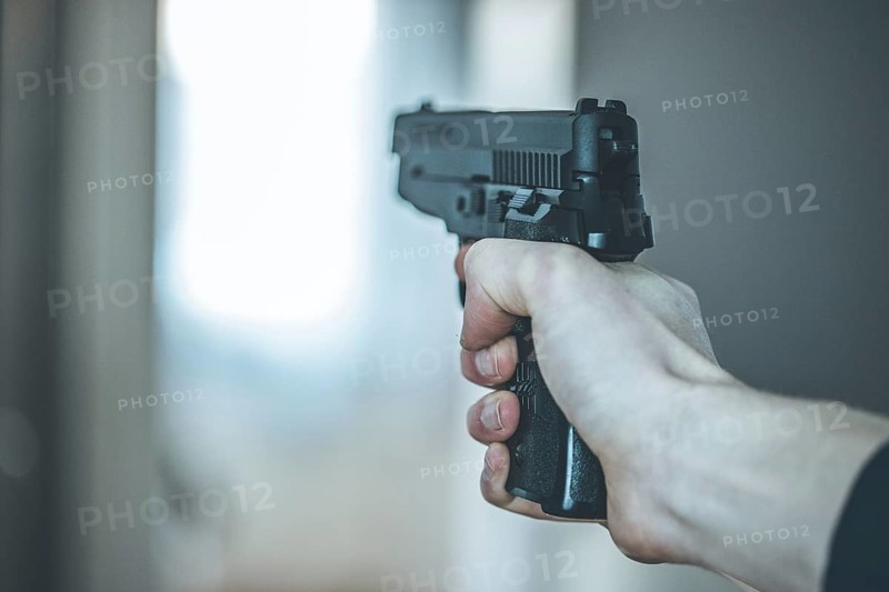 Man is holding a black fire weapon, closeup