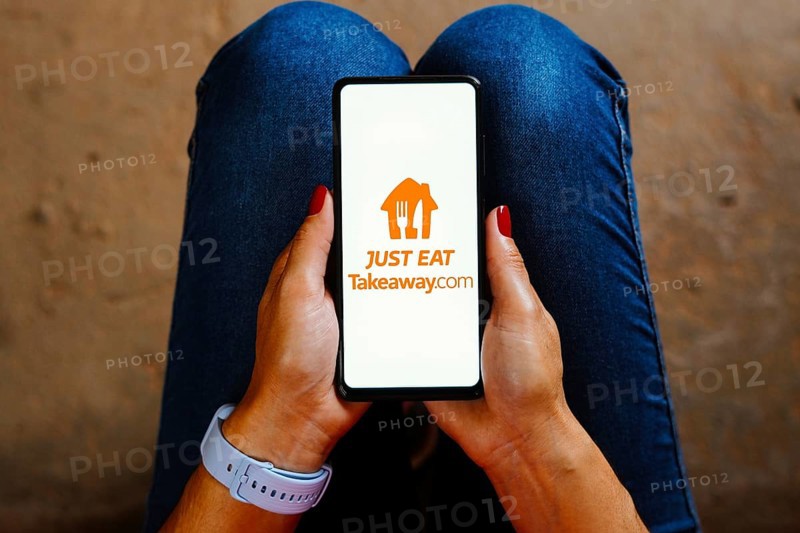 In this photo illustration, the Just Eat Takeaway logo is displayed on a smartphone screen
