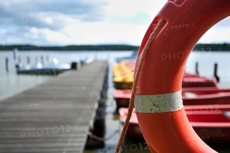 Lifebuoy and boats at the jetty, view over the Scharmützelsee, blurred background, Wendisch-Rietz, Brandenburg, Germany, Europe