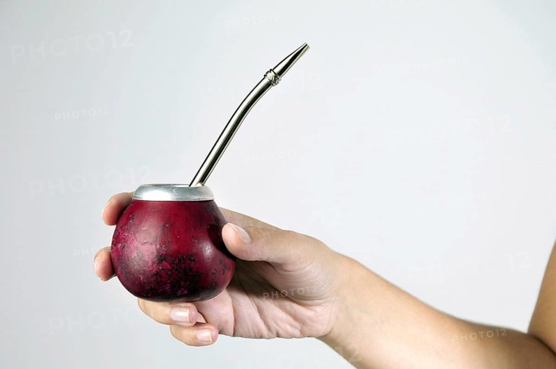 Hand and Yerba Mate drink on white background