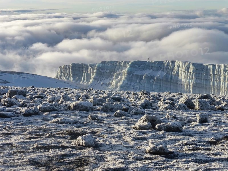 glacier remains and snow covered summit of Mount Kilimanjaro in Tanzania just after sunrise
