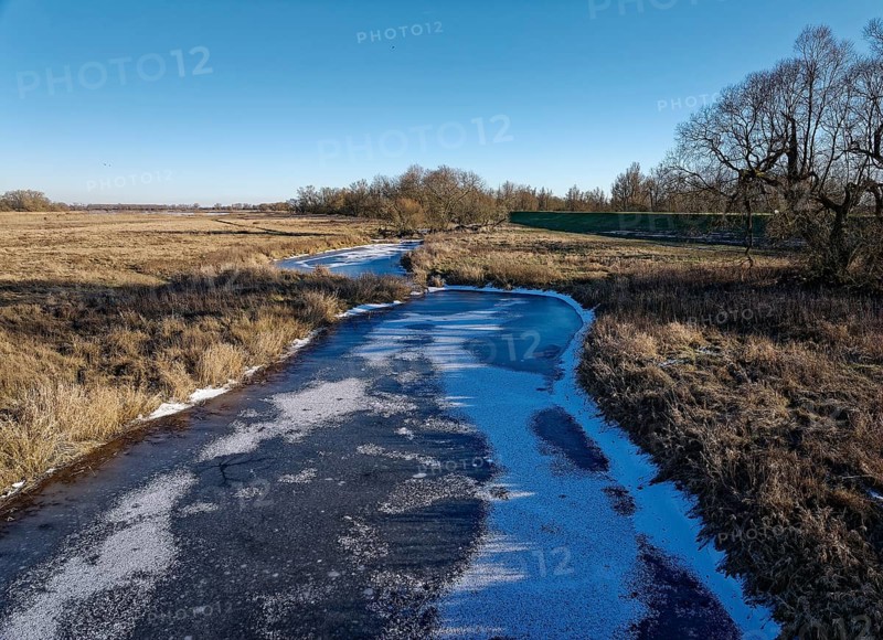 Icy drainage ditch on a winter's day in the floodplains of the Elbe valley near Neu Goldbeck. Seehausen, Altmark, Saxony-Anhalt, Germany, Europe