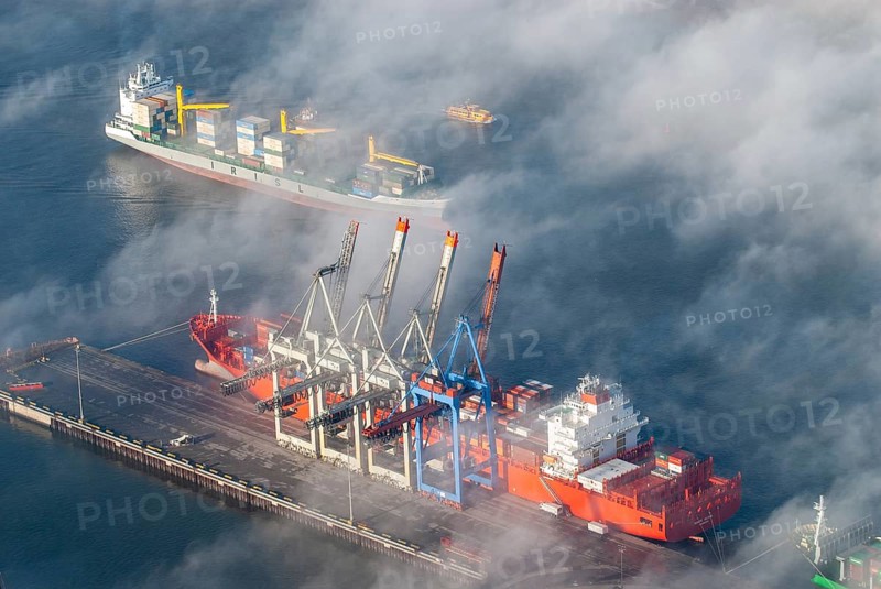 Aerial view of a container ship of the shipping company Hamburg Süd the Monte Olivia at the terminal Burchardkai. A container ship passes by on the Elbe, Hamburg, Germany, Europe